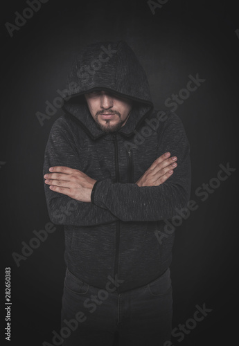 Mystery unknown man in hood on dark