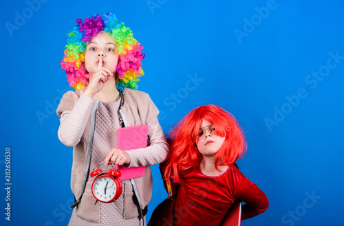 Circus school education. Time to have fun. Kids colorful curly wig clown style hold alarm clock. I am not joking about discipline. School alarm. Girl worry about time. Discipline and time concept