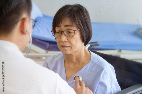 healthy concept; Doctor checking patient's heart with stethoscope at a hospital
