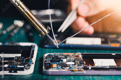Принти на полотні The technician repairing the smartphone's motherboard in the lab by soldering method