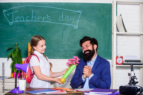 teachers day. Daugghter and father with flowers. small school girl kid with flower bouquet. knowledge day is 1 september. back to school. Happy teachers day. flower present for best teacher photo