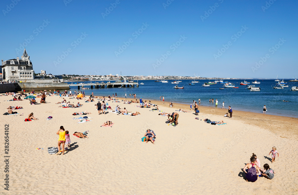 Cascais, Lisbon, Portugal - June 28, 2019: Tourists enjoy Ribeira Beach or Fisherman's Beach, in the center of Cascais, in Lisbon District, in Portugal.