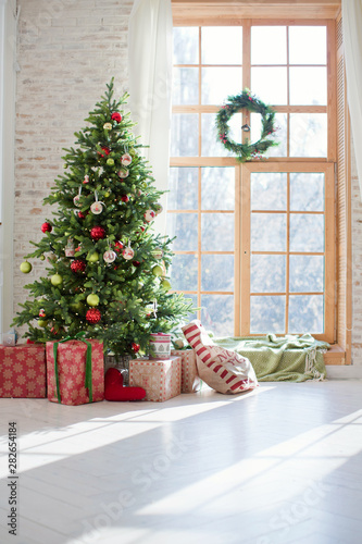 Christmas tree and gift boxes near the window