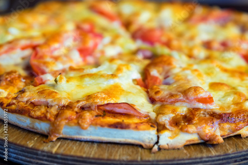 Delicious fresh pizza with tomatoes  salami and melted cheese close