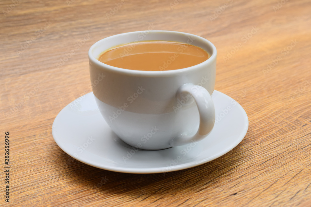  milk coffee in a cup with saucer