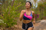 young attractive and exotic Asian Indonesian runner woman in jogging workout outdoors at countryside road track nature running sweaty pushing hard