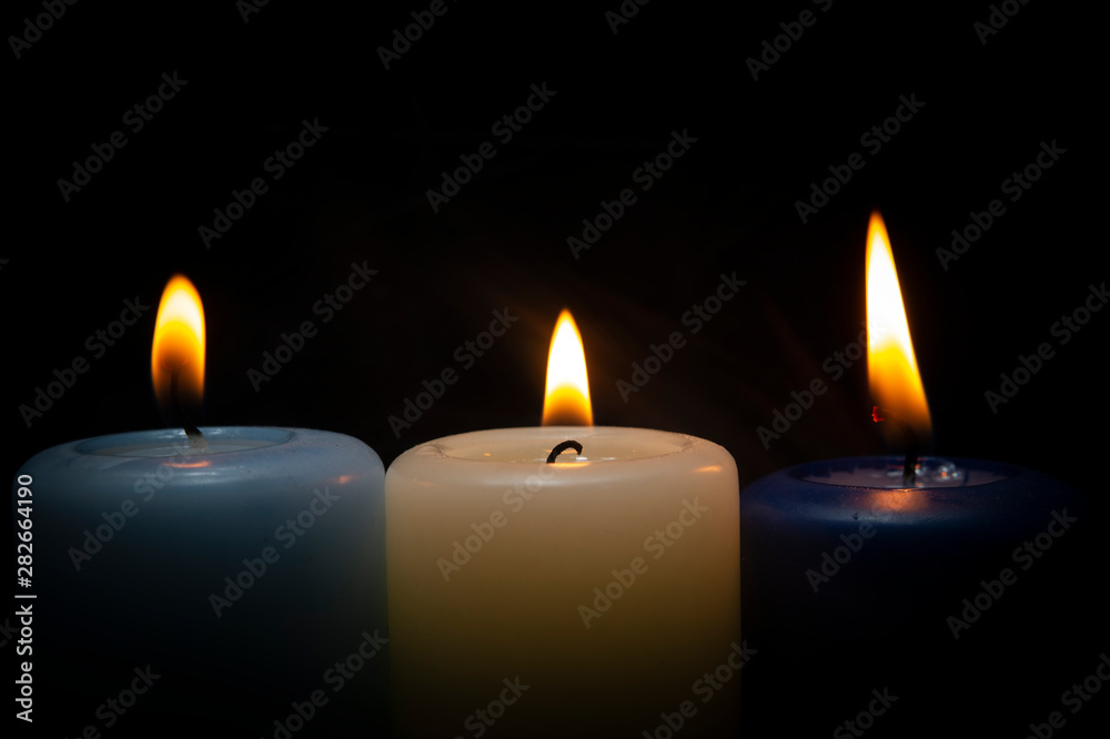 Close up of three colorful wax candles flame Close up of three colorful wax candles flame