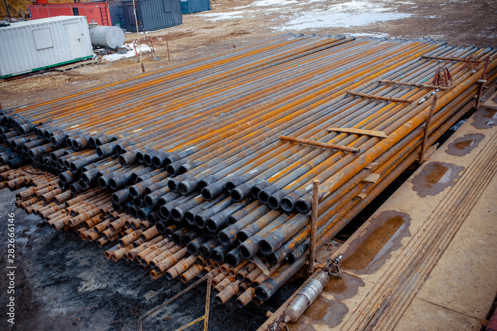 Drill pipe of oil drilling platforms. Stack of oil well casing bundles at the pin end of casing. Downhole drilling rig Drill pipe of oil drilling platforms. Stack of oil well casing bundles at the pin end of casing. Downhole drilling rig