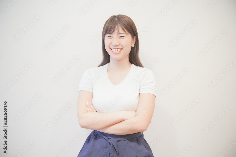 笑顔で腕を組む若い女性 笑顔で腕を組む若い女性