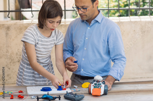 Father teaching his daughter electronics and robotics photo