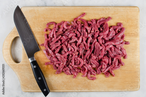 Meat for cooking stir fry on cutting board