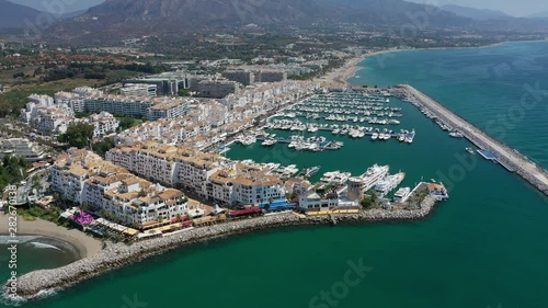 Aerial view of Puerto Banus near city of Marbella, many ships, boats and luxury yachts in port - landscape panorama of Andalusia from above, Costa del Sol (Mediterranean Sea), Spain, Europe photo