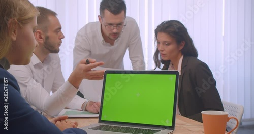 Wallpaper Mural Portrait of four collleagues meeting in the office indoors. Business people using the laptop with green chroma key screen and having a discussion on workplace Torontodigital.ca