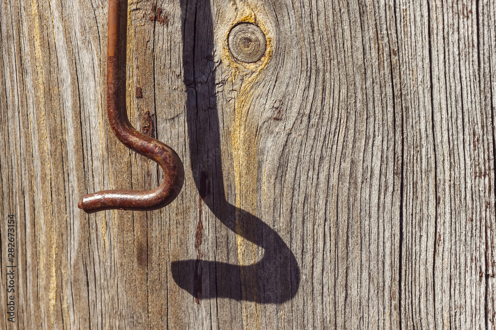 Old metal shutter hook on wooden boards. Wooden surface with old brown paint. Close-up, Old metal shutter hook on wooden boards. Wooden surface with old brown paint. Close-up,