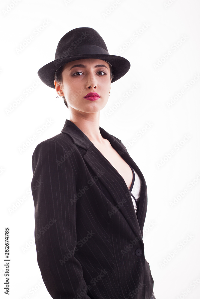 Portrait of beautiful young woman with short hair wearing a stylish black hat over white background in studio Portrait of beautiful young woman with short hair wearing a stylish black hat over white background in studio