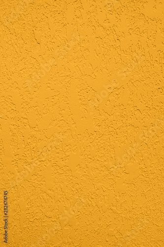 Saturated yellow colored low contrast Concrete textured background with roughness and irregularities to your concept or product.