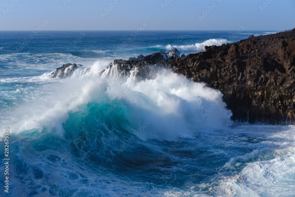 Scenic view of waves splashing on rocks at Los Hervideros Scenic view of waves splashing on rocks at Los Hervideros