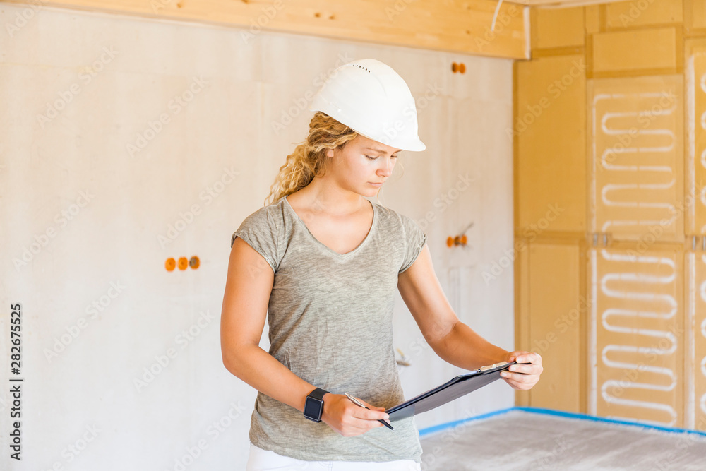 Young woman checking the construction of a new wooden house Young woman checking the construction of a new wooden house