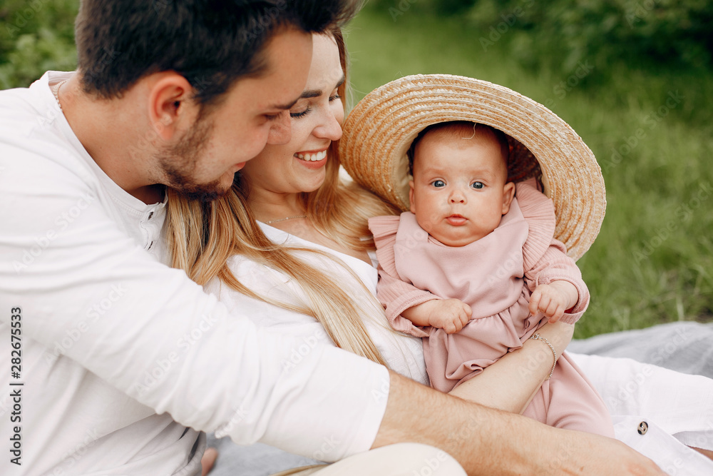 Family with cute little daughter. Father in a white t-shirt. Lady in a white dress Family with cute little daughter. Father in a white t-shirt. Lady in a white dress