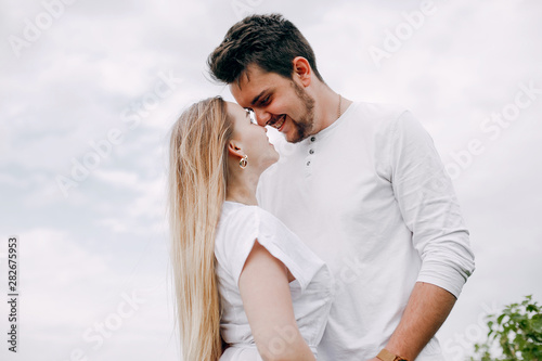 Couple in a field. Blonde in a white dress. Man in a white shirt