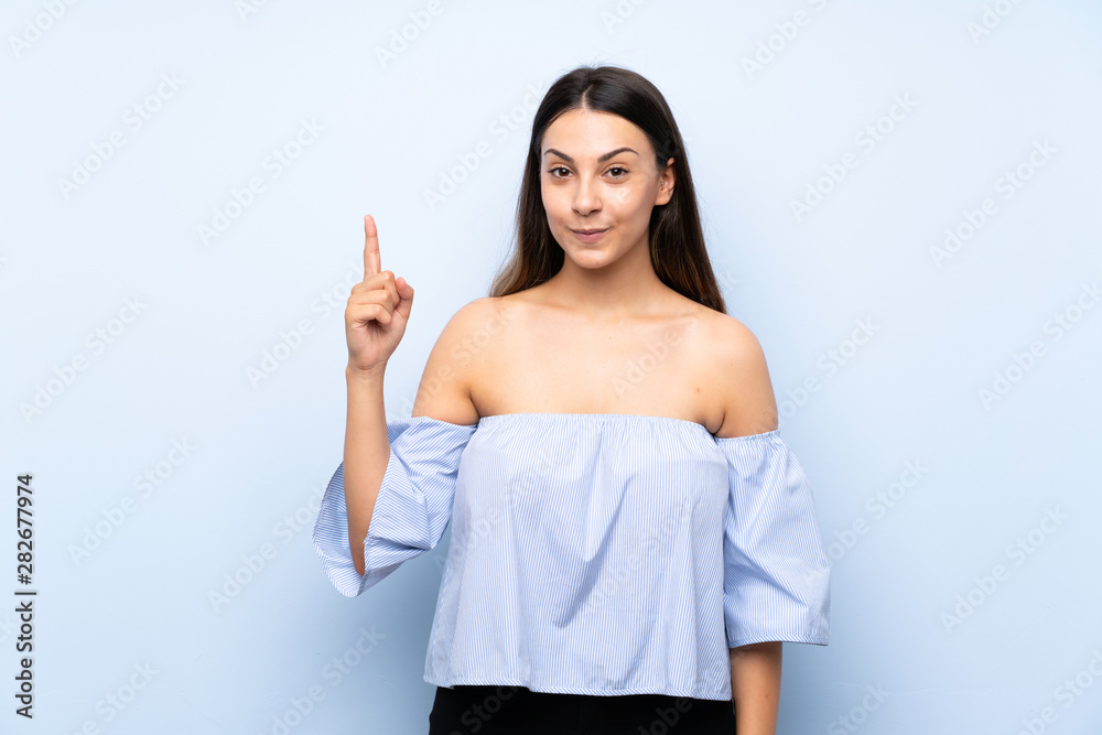 Young brunette woman over isolated blue background pointing with the index finger a great idea Young brunette woman over isolated blue background pointing with the index finger a great idea