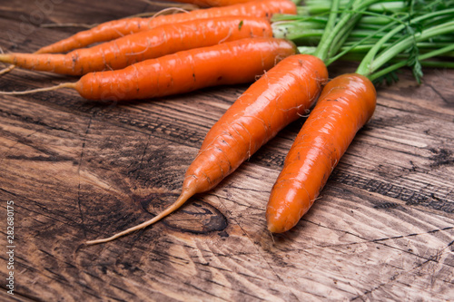 Close up of fresh carrot on rustic wooden background, top view