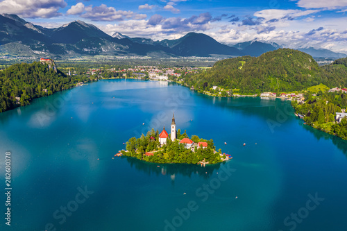 Fototapeta Naklejka Na Ścianę i Meble -  Bled, Slovenia - Aerial panoramic skyline view of Lake Bled (Blejsko Jezero) with the Pilgrimage Church of the Assumption of Maria, Julian Alps and Bled Castle at background on a sunny summer day