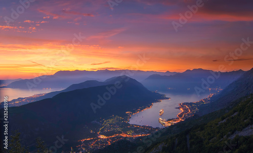 Kotor bay seen from above in a beautiful sunset summer day. Monenegro, View above houses, streets and port of kotor bay city with huge cruise ship anchoring by night