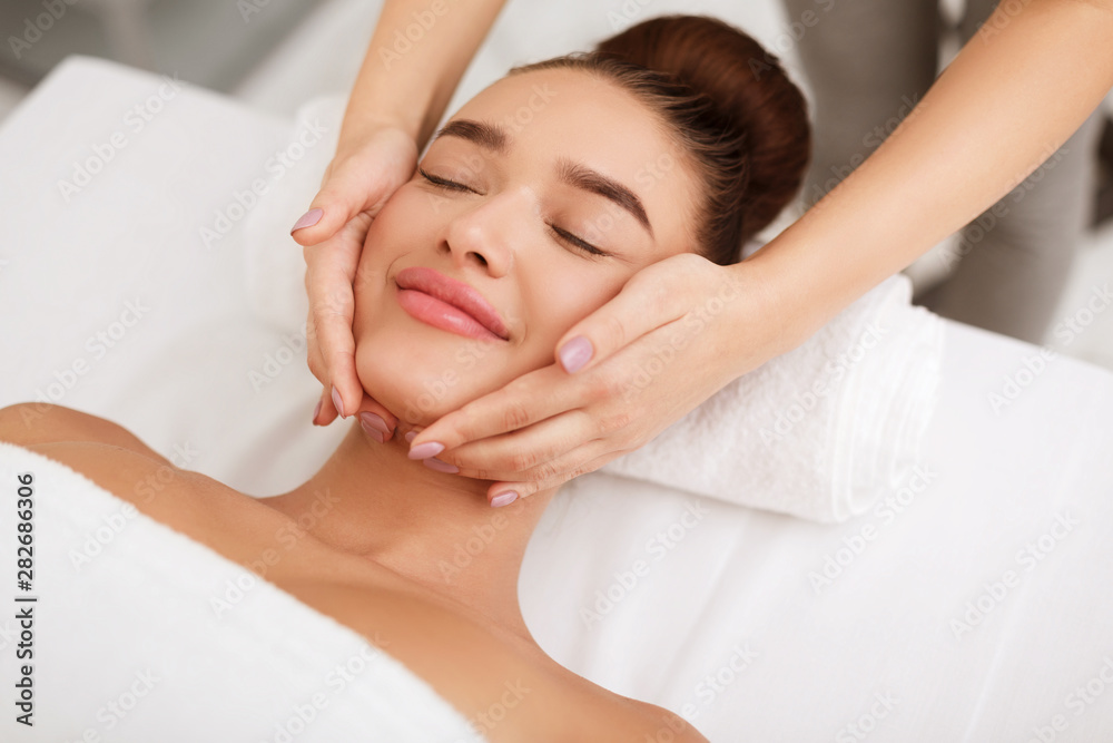 Face massage. Woman getting spa treatment in salon Face massage. Woman getting spa treatment in salon