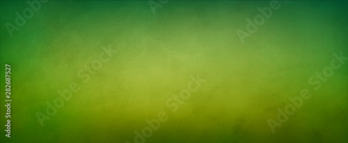 Abstract yellow green background with soft bright gold center glowing with light colors and dark blue green border with blurred mottled texture