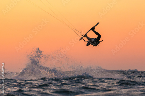 Kitesurfer doing unhooked tricks in beautiful sunset conditions and nice colors © Jens