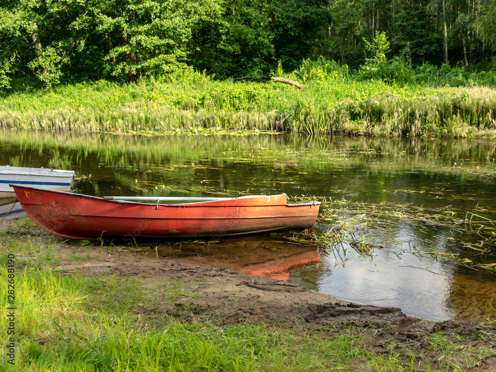 beautiful and bright boat on the banks of Seda river, beautiful reflections, Latvia