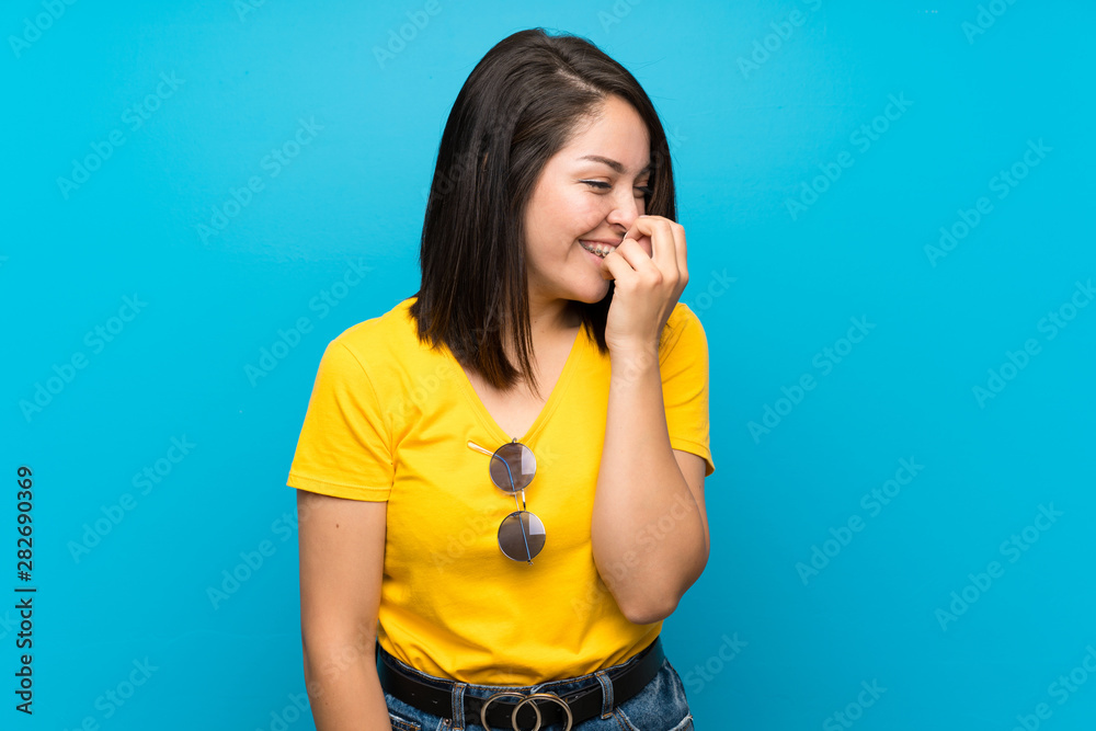 Young Mexican woman over isolated blue background smiling a lot Young Mexican woman over isolated blue background smiling a lot