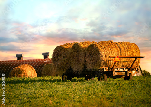 Photography Farm hay wagon filled with round bales of hay.