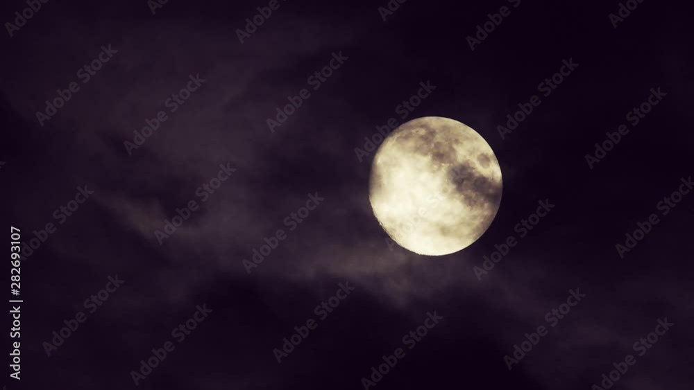 Moon With Clouds In The Night Sky. Concept of a spooky theme and mystery. Mysterious night sky with moon and dramatic clouds passing. Dark night with moon.