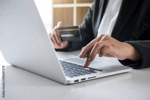 Business woman consumer holding credit card and typing on laptop for online shopping and payment make a purchase on the Internet, Online payment, networking and buy product technology © Ngampol