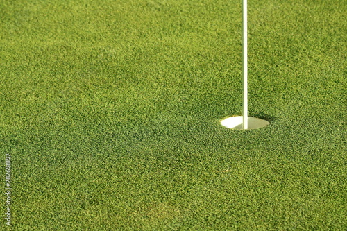 Close up of a golf green with flag in the hole.