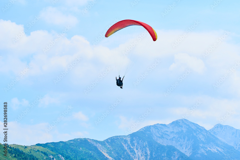 Paraglider flying over the Garda Lake (Lago di Garda or Lago Benaco), Panorama of the gorgeous Garda lake surrounded by mountains. Paragliding is very popular sport in Monte Baldo. Malcesine, Italy Paraglider flying over the Garda Lake (Lago di Garda or Lago Benaco), Panorama of the gorgeous Garda lake surrounded by mountains. Paragliding is very popular sport in Monte Baldo. Malcesine, Italy