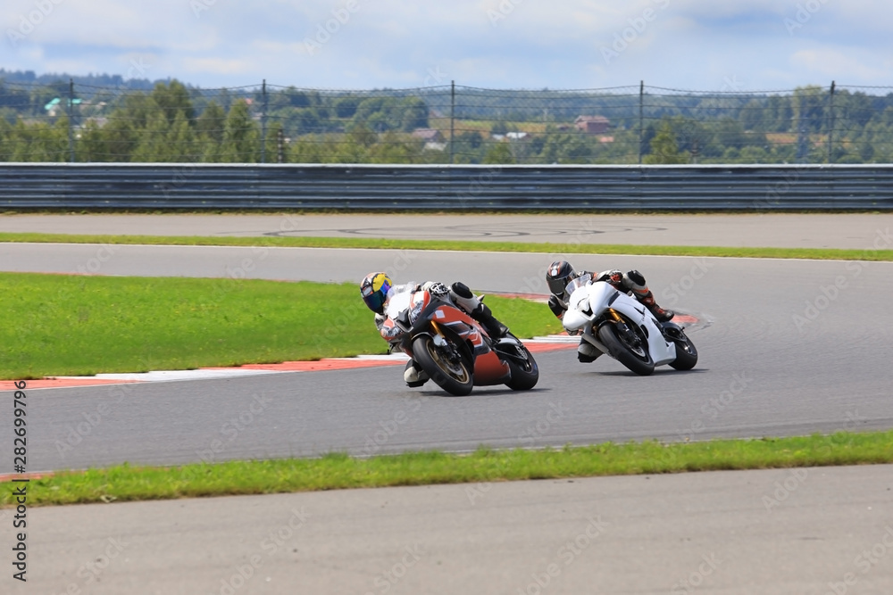 Two riders on motorcycles riding on the race track