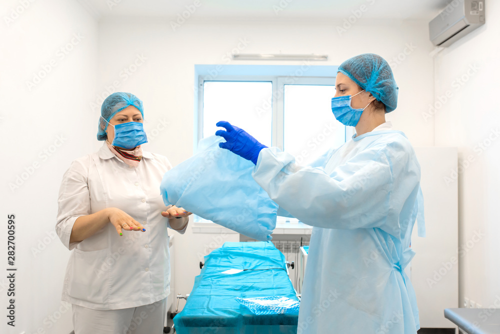 the nurse covers the operating table with a sterile cloth the nurse covers the operating table with a sterile cloth