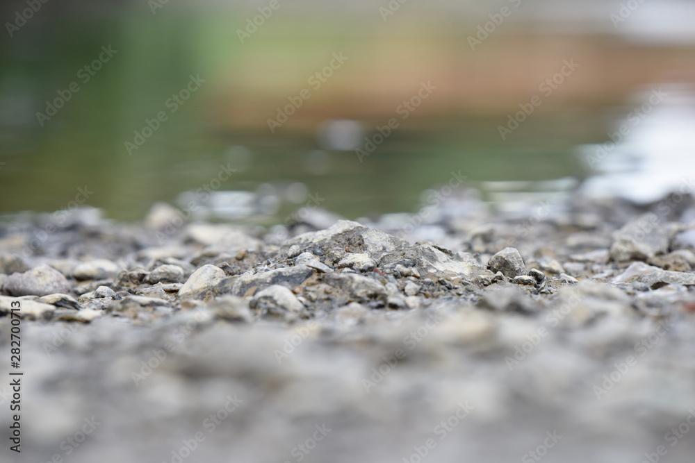 stones on the riverbank near the waterline stones on the riverbank near the waterline