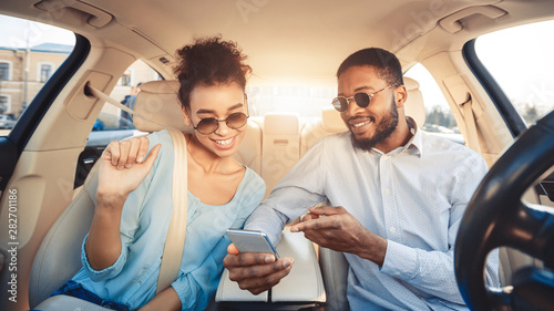 Fotografie Young couple driving car and using digital map