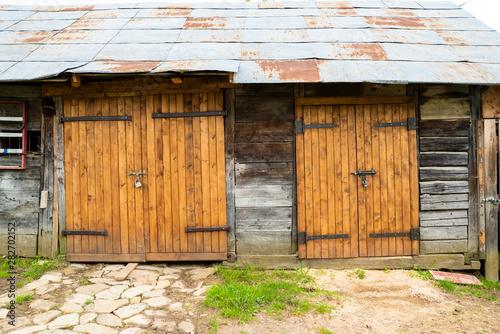 wooden gate in an old building with a tin roof in some places rusted