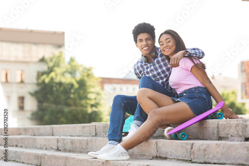Couple of teenagers sitting on stairs posing to camera