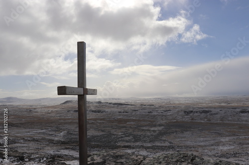cross on top of a mount tumbledown with snowy view 