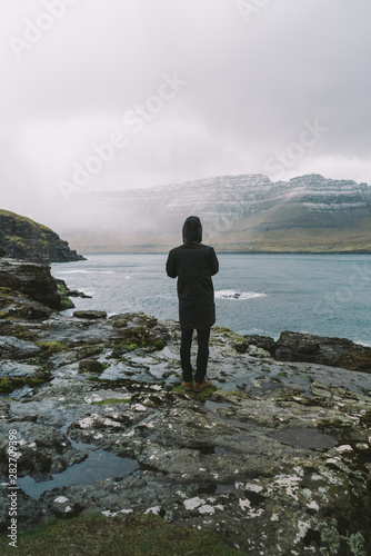 Man looking  at the ocean Faroe Islands