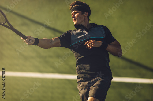 Tennis player practicing forehand on a hard court © Jacob Lund