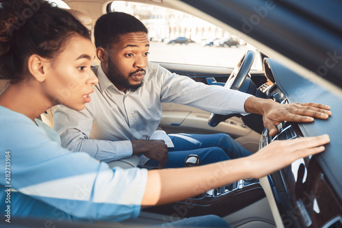 Surprised couple at car showroom choosing new auto