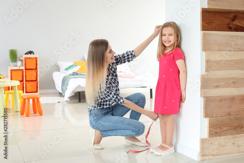 Young mother measuring heig...