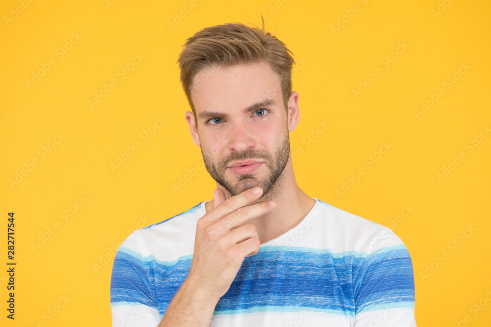Bearded moderately. Bearded man on yellow background. Unshaven guy touching his bearded chin. Handsome caucasian model with mustache and beard on bearded face Bearded moderately. Bearded man on yellow background. Unshaven guy touching his bearded chin. Handsome caucasian model with mustache and beard on bearded face